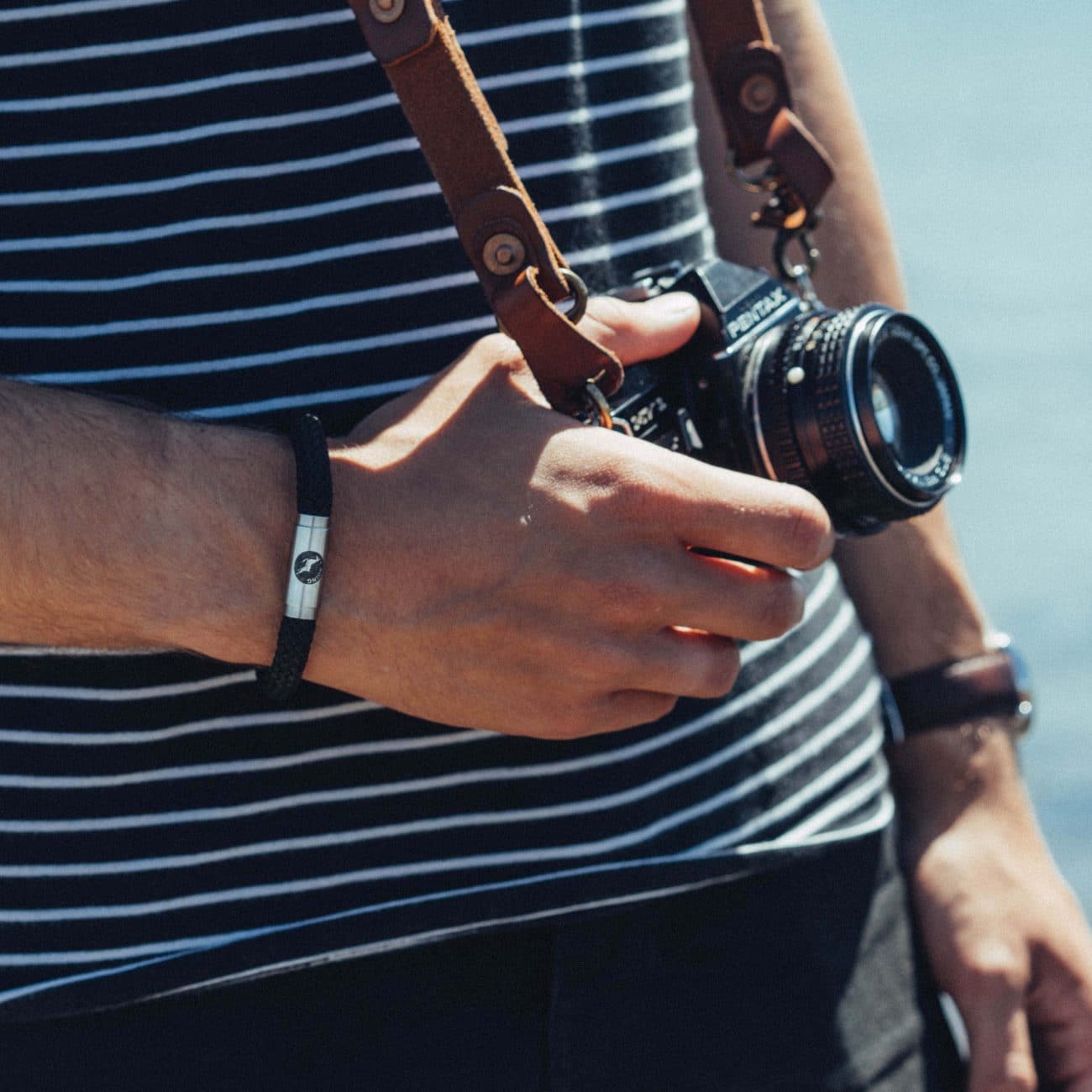 Man wearing black climbing rope bracelet outdoors